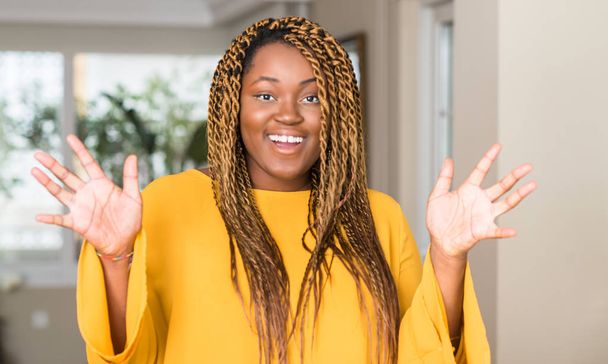 Mujer afroamericana en casa muy feliz y emocionada, expresión ganadora celebrando la victoria gritando con una gran sonrisa y levantando las manos
 - Foto, imagen