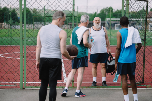 группа многорасовых старых спортсменов с баскетбольным мячом на детской площадке
 - Фото, изображение