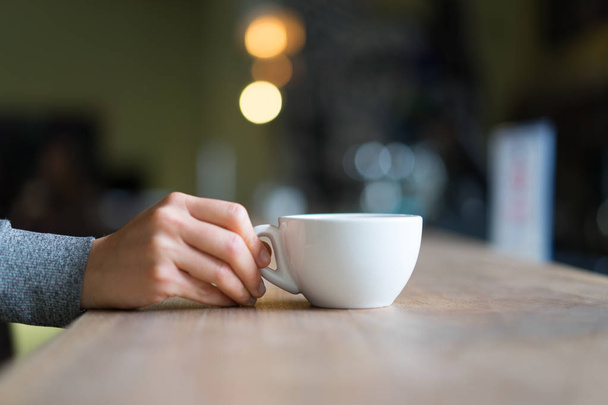 Κούπα τσάι ή καφέ, που κρατούνται με θολή φόντο - Φωτογραφία, εικόνα