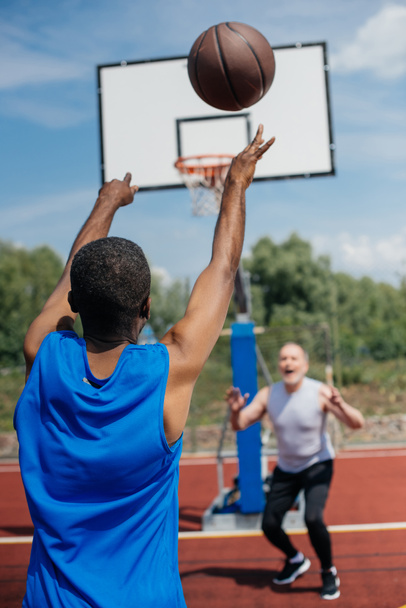 multiracial elderly men playing basketball together on playground on summer day - Zdjęcie, obraz
