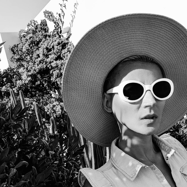 Vintage Girl in fashion accessories. Hat and sunglasses in plant location. Beach retro mood - Фото, зображення