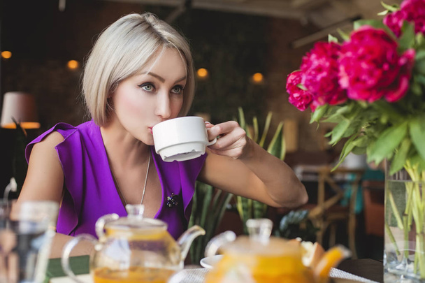 Pretty woman drinking herbal tea in restaurant - Photo, image