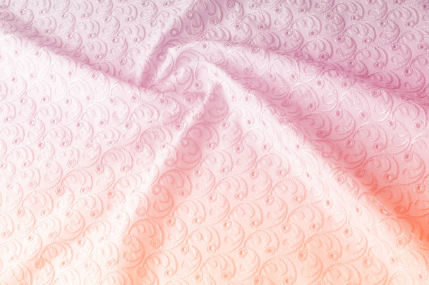 De achtergrond van de textuur van de stof. Doek met geperforeerde cirkels. De textuur van de stof is geschilderd in pasteltinten van roze kleur, detail van een roze katoenen doek textuur achtergrond in pastel kleuren. - Foto, afbeelding