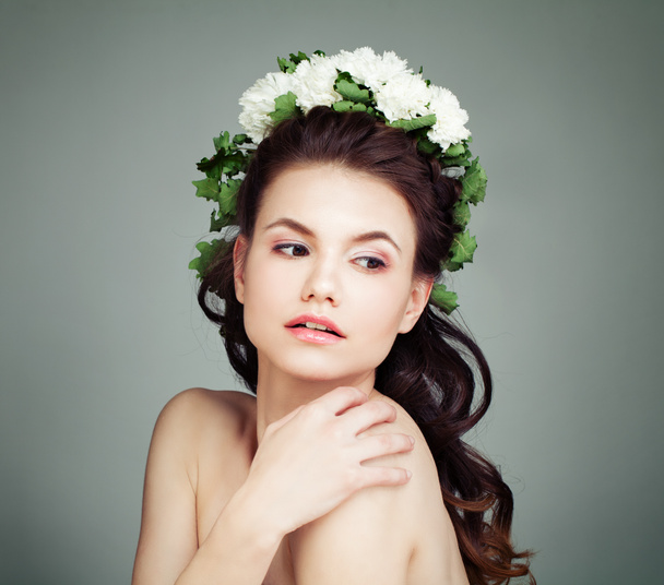 Fiatal női modell fehér virágok és zöld levelek haj - Fotó, kép