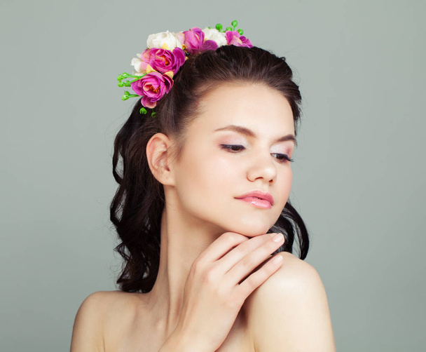 Happy Prom Girl con peinado perfecto y maquillaje aislado sobre fondo blanco. Mujer joven con flores en el pelo
 - Foto, Imagen