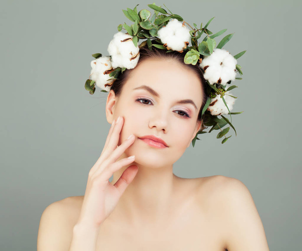 Mulher modelo bonito com pele saudável e flores de algodão branco. Conceito de Cuidados com a pele e Cosmetologia
 - Foto, Imagem