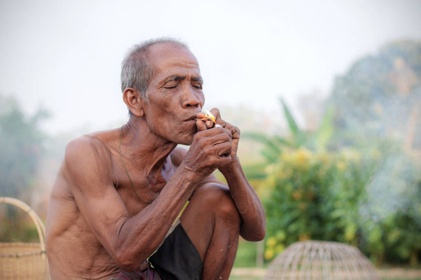 Osoby starsze są palenie na wsi. - Zdjęcie, obraz