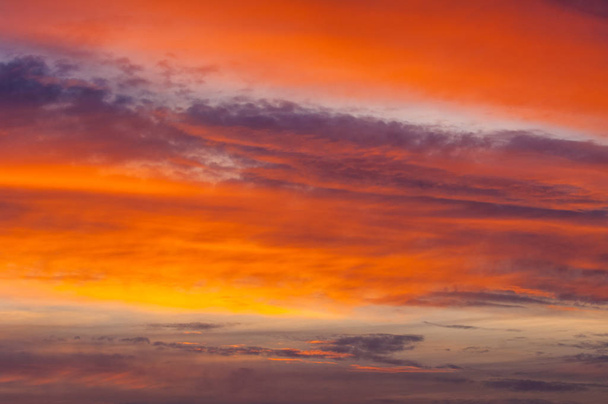 Textur, Hintergrund, Muster. Abend, Morgenhimmel, helle Farben auf den Wolken, bunter Himmel und Sonnenaufgang. Naturlandschaft. frühmorgendlicher Himmel mit Farben von tiefblau bis orange.  - Foto, Bild