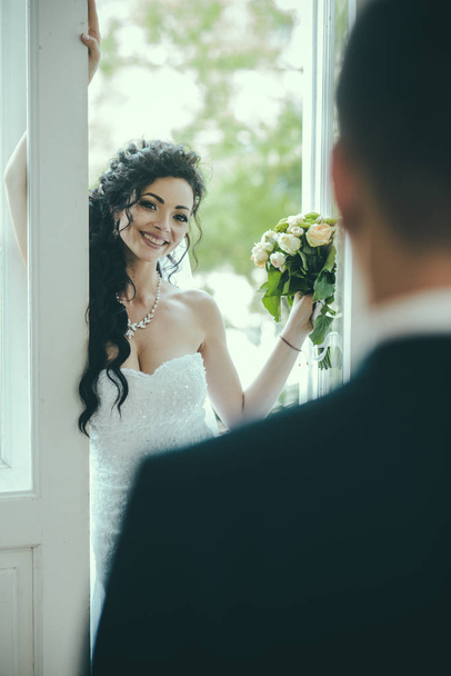 Sensual woman with bridal makeup and hairstyle. Happy bride smile to groom. Woman and man on wedding day. Fashion girl with glamour look and beauty. Wedding concept. love and romance - Foto, afbeelding