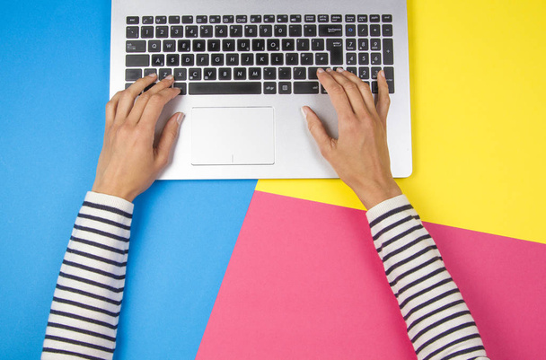 Ręce kobiety za pomocą laptopa na kolorowe tło - Zdjęcie, obraz