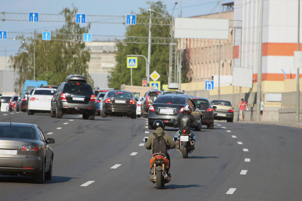 Verkehr von Autos und Motorrädern auf einer Stadtstraße - Foto, Bild