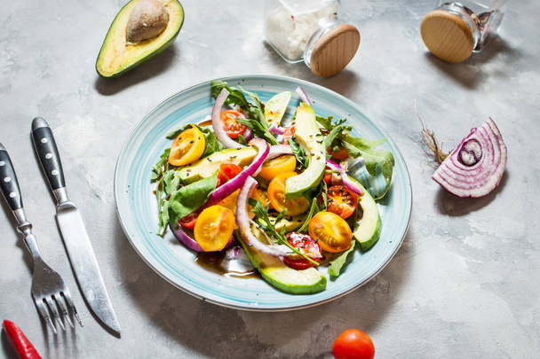 Salad with tomatoes and avocado on concrete background. - Fotografie, Obrázek