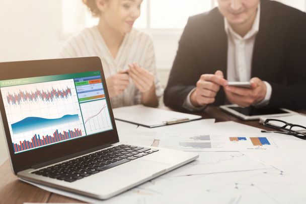 Ноутбук с финансовым графиком и деловой встречей
 - Фото, изображение