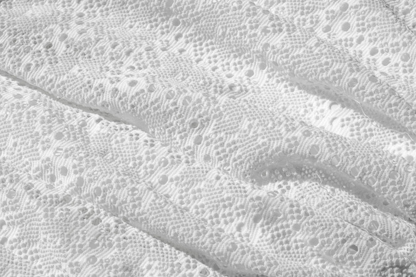 Textuur, achtergrond, patroon. Witte rok meisje, met een gebroken patroon in de vorm van cirkels. Witte kant katoen - Foto, afbeelding