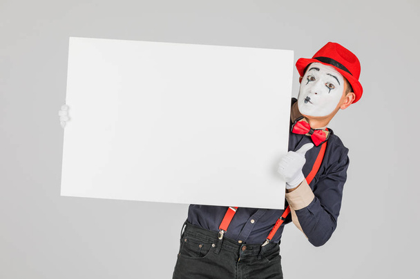 happy MIME artist holding a blank white Board, on a white background - Foto, Imagen