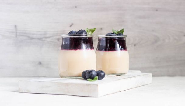 Coffee panna cotta with berry coulis and fresh blueberries. Delicious Italian dessert panna cotta - Foto, imagen