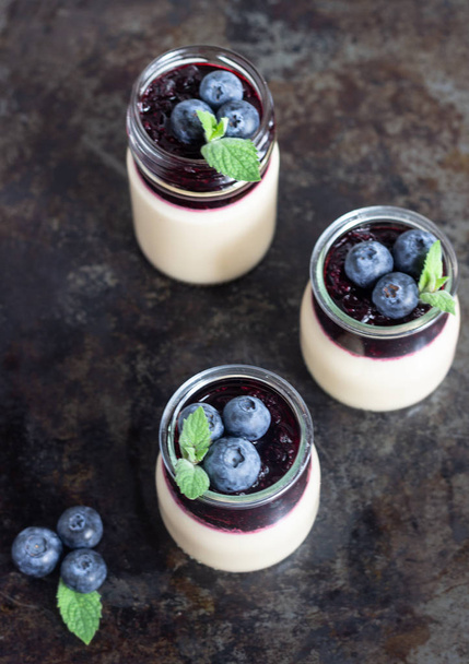 Coffee panna cotta with berry coulis and fresh blueberries. Delicious Italian dessert panna cotta - Fotoğraf, Görsel