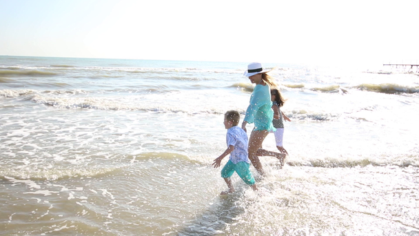 ευτυχισμένη μαμά παίζουν Γουίτ τα παιδιά της με τη θάλασσα  - Πλάνα, βίντεο