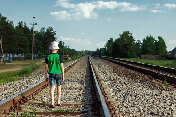 The child goes on rails, walks on rails. Danger, road, choice of profession. - Fotoğraf, Görsel