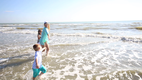 ευτυχισμένη μαμά παίζουν Γουίτ τα παιδιά της με τη θάλασσα  - Πλάνα, βίντεο