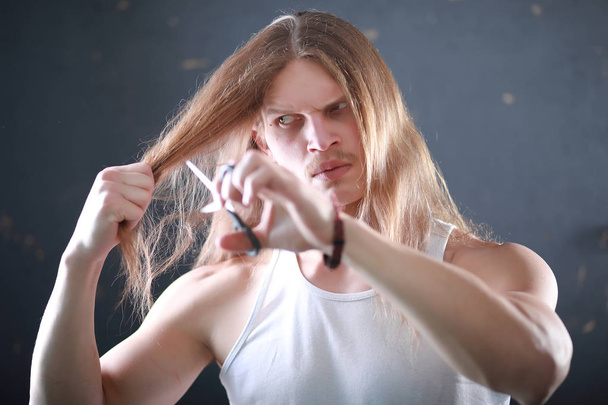 Un giovane con i capelli lunghi tagliare una serratura
 - Foto, immagini