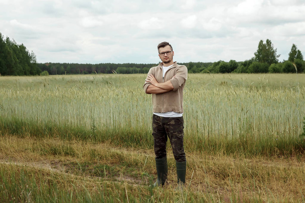 The man is a farmer, standing in his field. Farmland, new technologies, harvesting, fertilization, crop inspection. - Fotografie, Obrázek