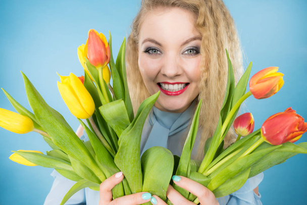 International womens day, eight march. Beautiful portrait of pretty woman blonde hair with red yellow tulips, fashion make up. Mothers day. On blue - Fotoğraf, Görsel