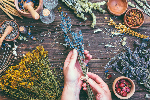Ramo de mano femenina hierbas medicinales alternativas fondo de madera Vintage Country Style muñón, libra
 - Foto, imagen