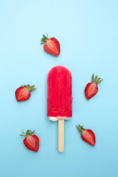 Strawberry popsicle with fresh strawberry on a blue background - Foto, imagen