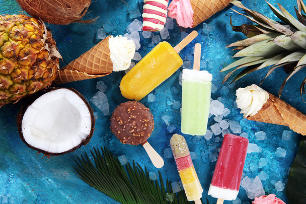 Vanilja jäädytetty jogurtti tai pehmeä jäätelö vohveli kartio ja värikäs mehujää trooppisia hedelmiä
 - Valokuva, kuva