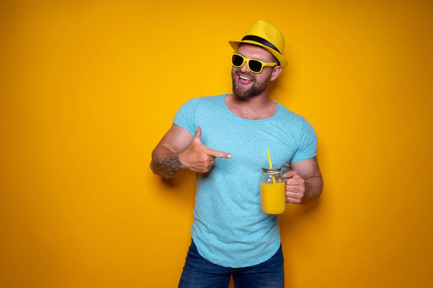 Man posing with bright orange drink - Фото, зображення