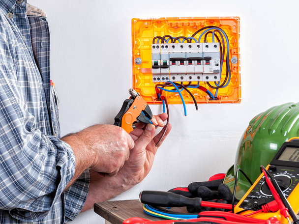 Técnico de eletricista no trabalho com stripper de fio em cabos em uma instalação elétrica residencial
. - Foto, Imagem