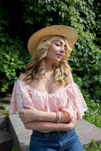 Inschrijving jonge vrouw strooien hoed en lace blouse met naakte schouders dragen - Foto, afbeelding