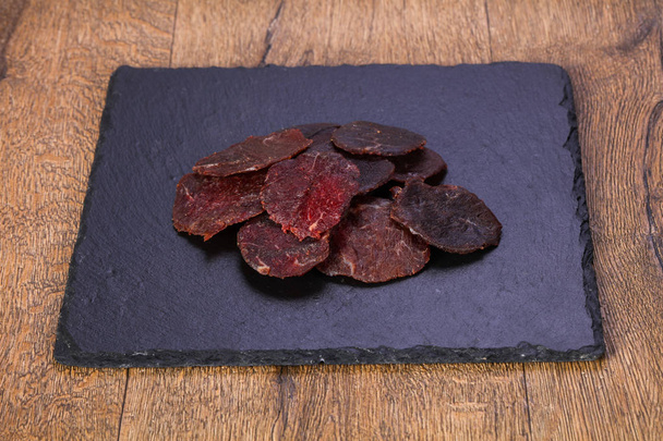 Carne seca de res sobre madera
 - Foto, imagen