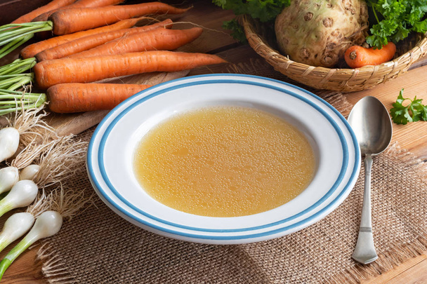 Chicken bone broth with vegetables on a table - Photo, Image