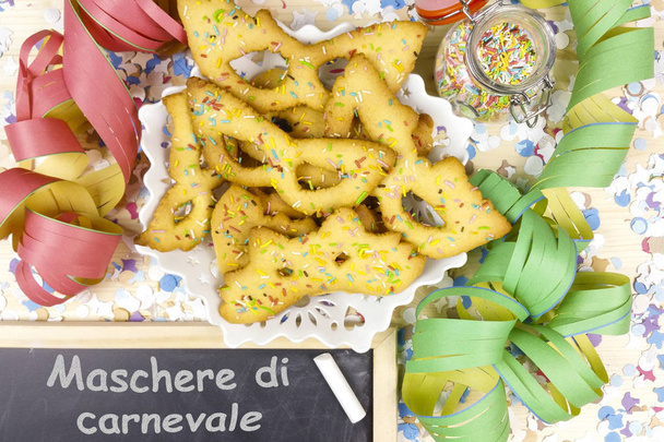 Καρναβάλι μάσκες μικρού ζαχαροπλαστικής με σερπαντίνες σε ξύλο φόντο - κάτοψη - Φωτογραφία, εικόνα