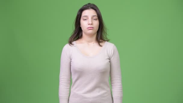 Mujer estresada joven hombros encogiéndose de hombros contra fondo verde
 - Metraje, vídeo