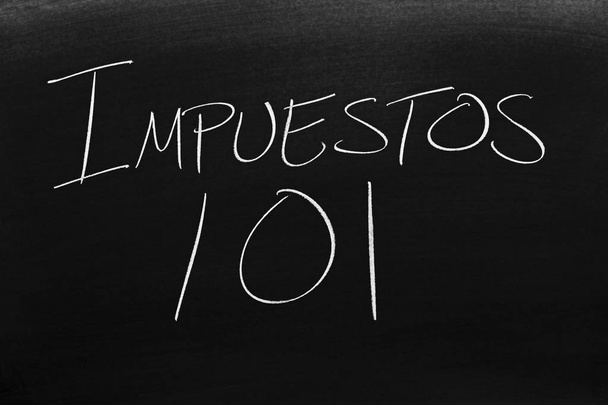 De woorden Impuestos 101 op een bord met krijt. Vertaling: Belastingen 101 - Foto, afbeelding