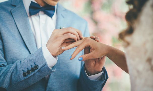 Bridegroom put an engagement ring on bride. - Foto, imagen