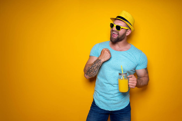 Man posing with bright orange drink - Photo, Image
