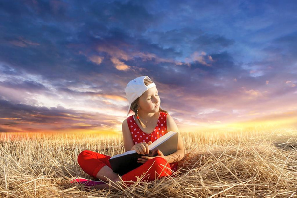 Libro de lectura infantil o biblia al aire libre. Las manos de un niño pequeño orando sobre la Santa Biblia. El mundo interior del niño. Relajación al aire libre. Retrato
  - Foto, imagen