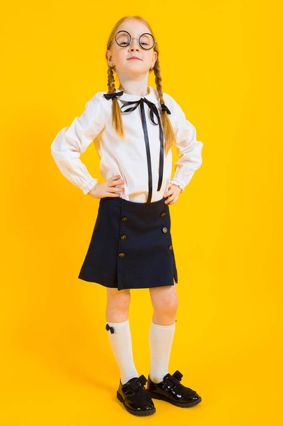 Girl with red pigtails on a yellow background. Beautiful girl in round transparent glasses. - Fotó, kép