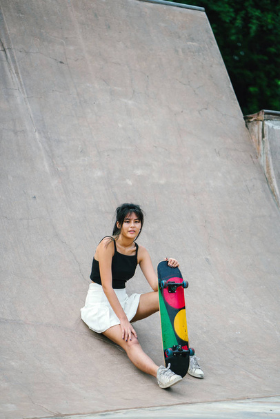 Chinese girl with skate in skatepark - Фото, изображение