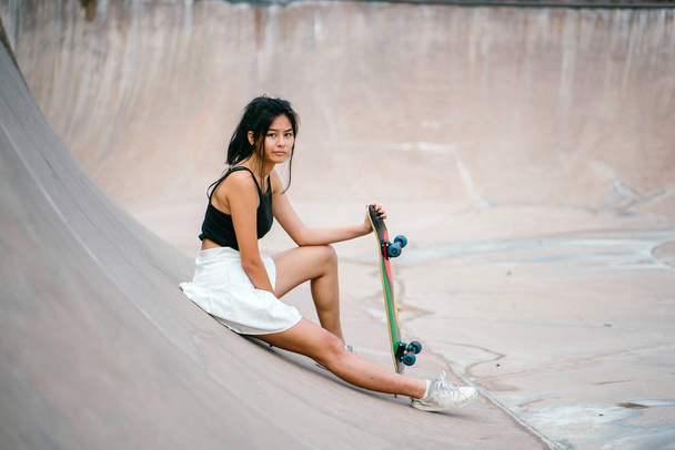 Chica china con patín en skatepark
 - Foto, imagen