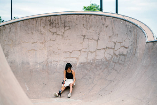 Chinese girl with skate in skatepark - Foto, imagen
