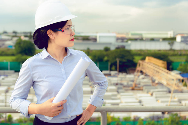 Portrait of engineer woman is holding paperwork for inspection precast concrete product in factory. - 写真・画像