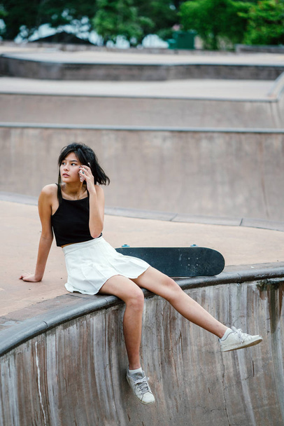 Portrait of Asian Chinese girl with skate in skatepark - 写真・画像