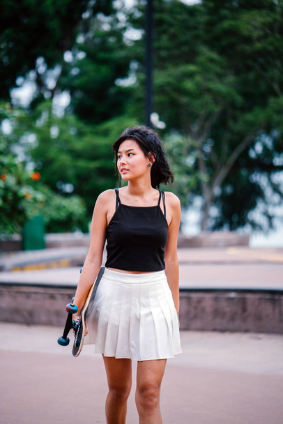 Portrait of Asian Chinese girl with skate in skatepark - Fotó, kép