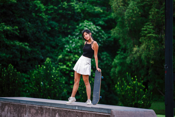 Portrait of Asian Chinese girl with skate in skatepark - Foto, Imagen