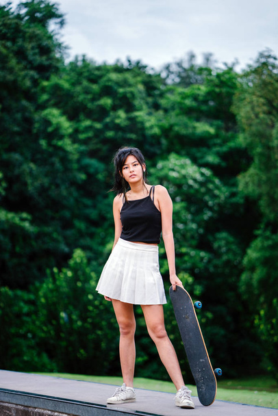 Portrait of Asian Chinese girl with skate in skatepark - Фото, изображение